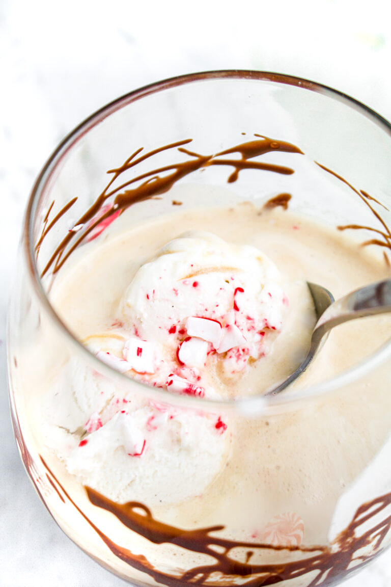 Overhead close up view of a spoon digging into a small glass of vegan affogato with chocolate sauce and peppermint