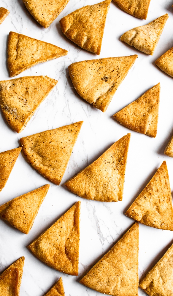 Make your own pita chips in the air fryer with just 4 ingredients and 20 minutes of your time! Perfect for snacking or dipping in hummus. #vegan #veganrecipe #airfryer #airfryerrecipes #pitachips #easyveganrecipes #vegansnack #homemade