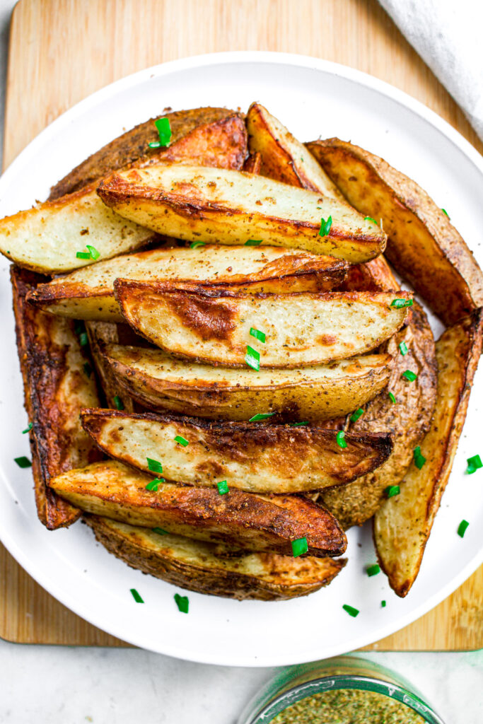 Overhead close up view of a pile of crispy wedges sprinkled with minced green onion