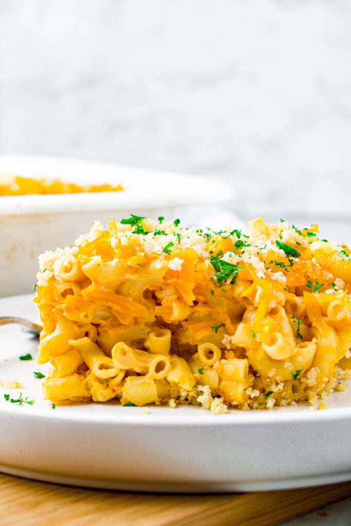 Head-on shot of a slice of dairy-free mac and cheese with melty vegan cheddar and minced parsley on top
