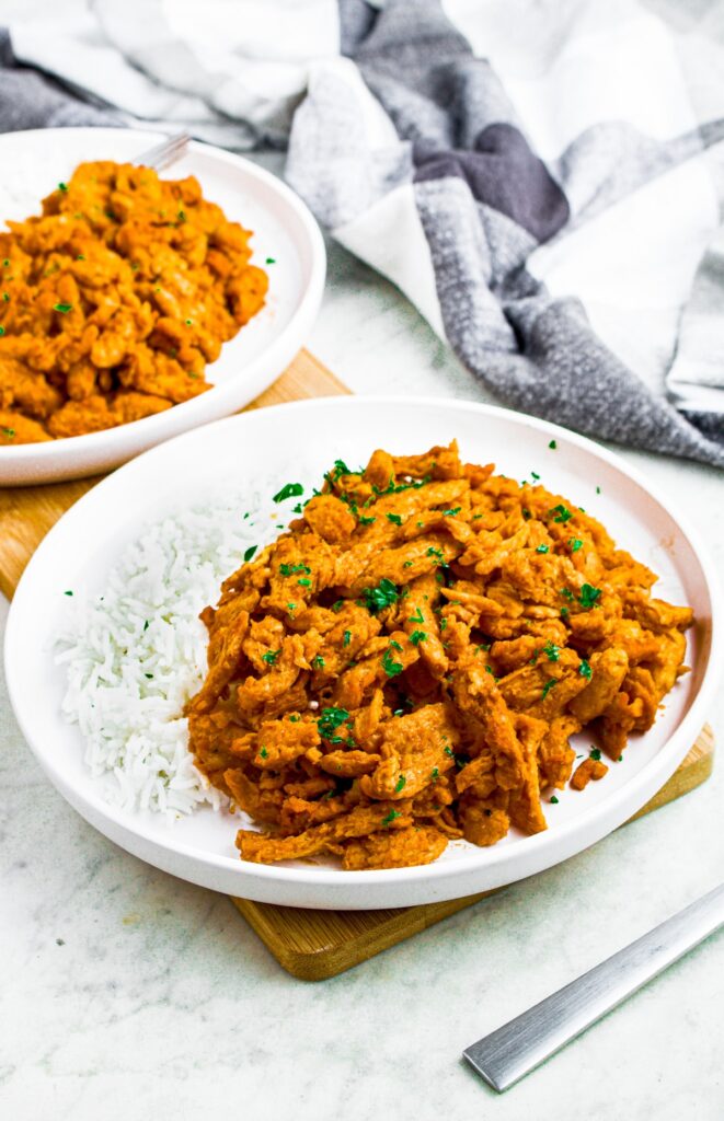 Head on shot of a round white plate piled high with spicy soy curl chicken pieces