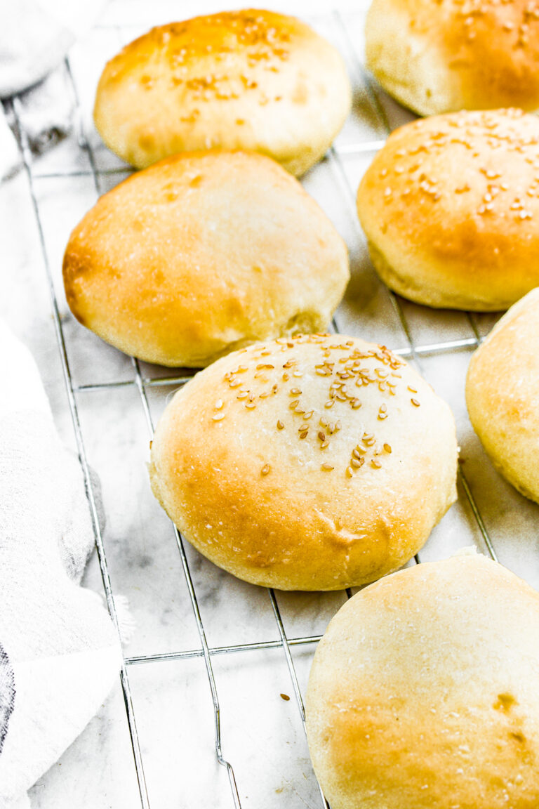 Overhead photo of a row of vegan buns topped with sesame seeds