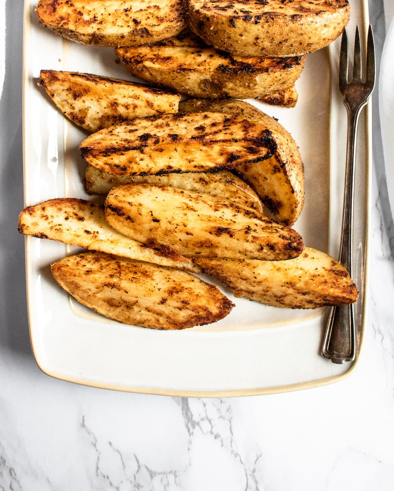 These cast iron potato wedges recipe is easy to make, super dependable, and can be altered to your specific spice/flavor desires. A healthier alternative to french fries, they’re great paired with ALL your summer grilling favorites or just as a snack served with ALL the dips! #vegan #potatoes #potatowedges #plantbased #castiron #comfortfood #veganrecipe