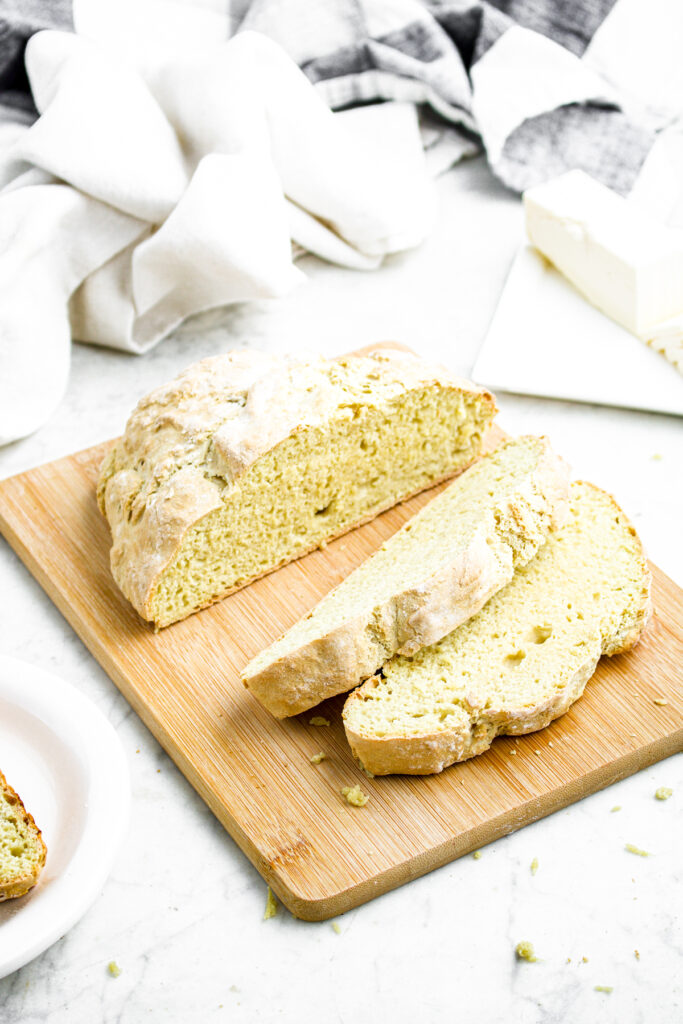 Overhead view of a partially sliced no yeast bread loaf on a wooden cutting board