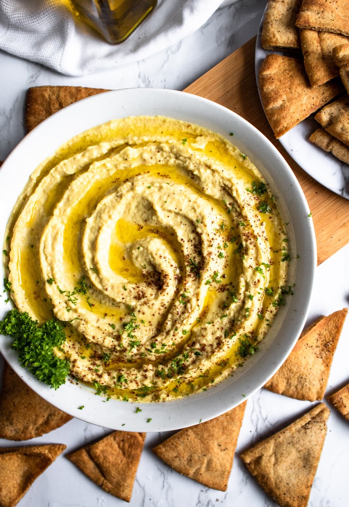 This Extra Garlic Hummus (emphasis on the “EXTRA”) is the perfect snack or appetizer for all our fellow garlic lovers out there! It’s an easy-to-make 10-ingredient dip with a dynamite flavor and silky smooth texture that will not disappoint. #vegan #vegansnack #veganappetizer #plantbased #hummus #hummusrecipe #garlic #garlicrecipe