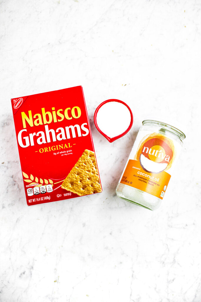 Overhead photo of all the ingredients you need to make graham cracker crust: graham crackers, coconut oil, sugar