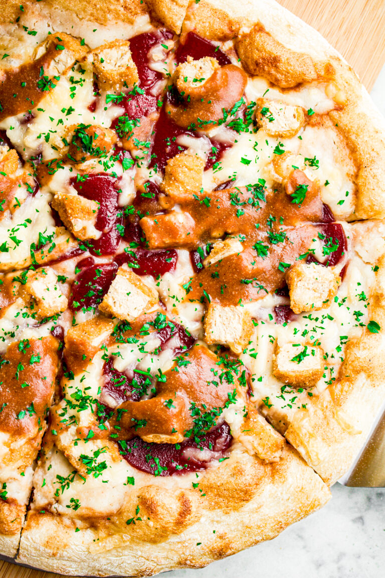 Close up overhead view of half a vegan Christmas pizza with mashed potatoes, cranberry sauce, and gravy