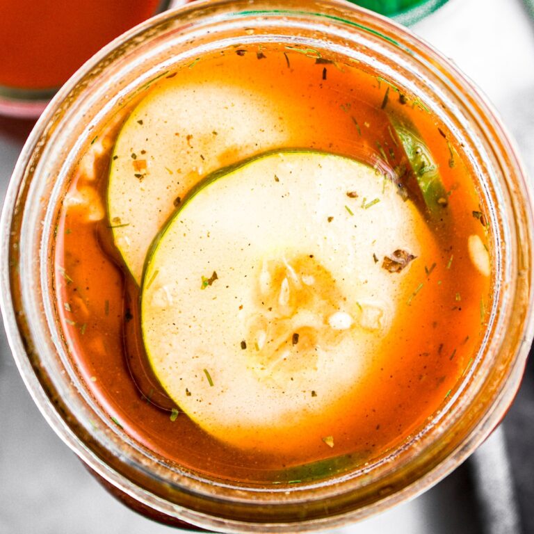 Overhead zoomed in view of a jar of spicy buffalo pickles in a homemade brine