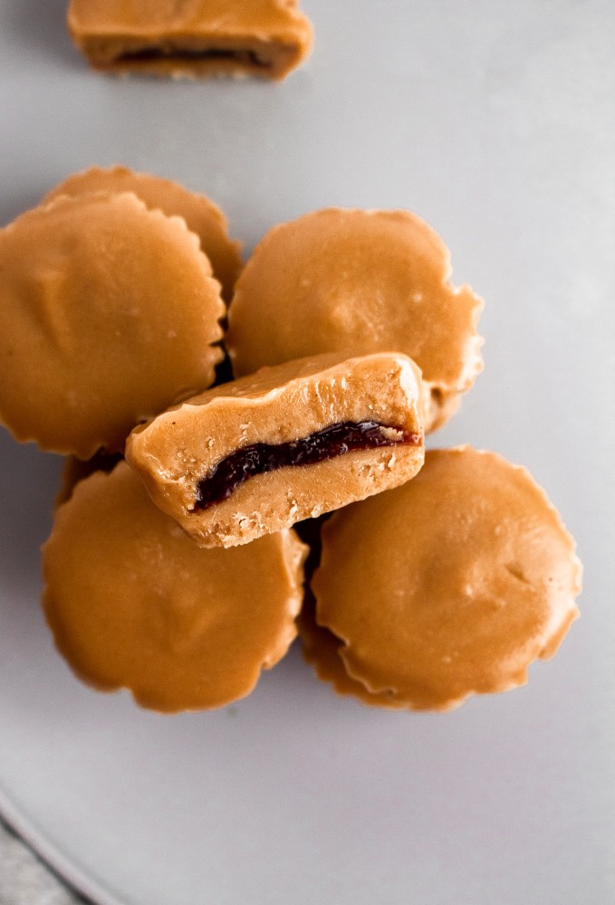 PB + J meets peanut butter cup in this killer combo of classic comfort foods! These delightful PB+J Cups are easy to make with only 4 ingredients, simple methods, and no heat required. They’re the ultimate summer sweet for your kids or the kid in us all! #vegan #dairyfree #vegancandy #veganrecipes #glutenfree //plantpowercouple.com