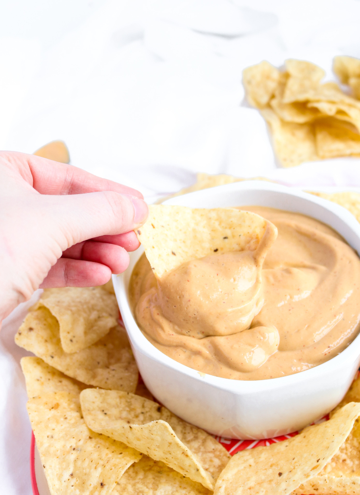 Make this incredible vegan queso in 5 minutes flat, no cashew-soaking or even a stove top required! It's creamy and flavorful and just begging to be poured (slow-mo-style) over all your nachos, tacos, and basically your entire life.﻿ #vegan #queso #superbowl #snack #appetizer #tacotuesday #veganrecipes #oilfree // plantpowercouple.com