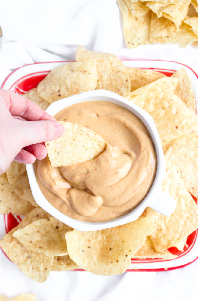 Make this incredible vegan queso in 5 minutes flat, no cashew-soaking or even a stove top required! It's creamy and flavorful and just begging to be poured (slow-mo-style) over all your nachos, tacos, and basically your entire life.﻿ #vegan #queso #superbowl #snack #appetizer #tacotuesday #veganrecipes #oilfree // plantpowercouple.com