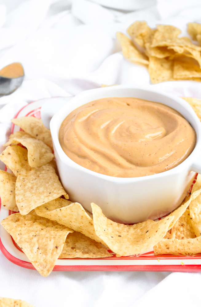 Make this incredible vegan queso in 5 minutes flat, no cashew-soaking or even a stove top required! It's creamy and flavorful and just begging to be poured (slow-mo-style) over all your nachos, tacos, and basically your entire life.﻿ #vegan #queso #superbowl #snack #appetizer #tacotuesday #veganrecipes #oilfree // plantpowercouple.com