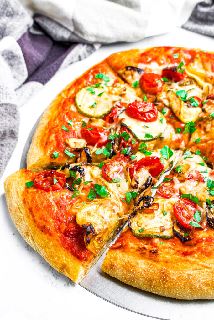 Overhead view of a vegan veggie pizza with fresh summer garden vegetables