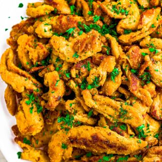 Overhead close up photo of soy curl chicken pieces on a round white plate.