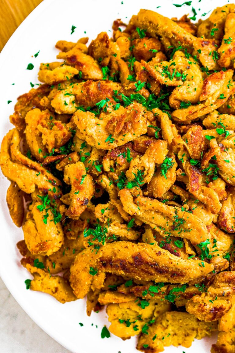 Overhead close up photo of soy curl chicken pieces on a round white plate.