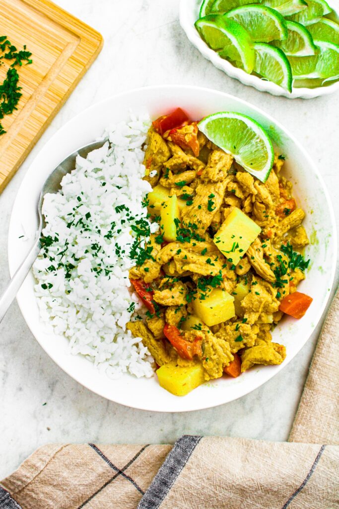 Overhead photo of a bowl with vegan chicken curry on one side and basmati rice on the other.