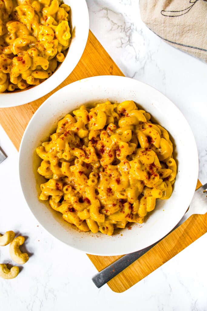 Overhead shot of easy vegan mac and cheese with dairy free sweet potato cheese sauce in a white bowl with another bowl off to the side