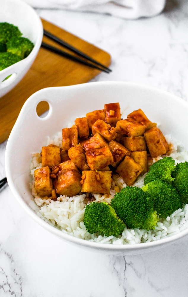 This easy air fryer tofu with a sweet sriracha sauce is our favorite quick tofu recipe! It’s perfect for a healthy weeknight dinner or meal prep lunch. Tofu is diced and air fried (with no oil needed!) and then tossed in a sweet and spicy sriracha sauce. Serve this sweet sriracha tofu recipe over rice and roasted veggies or in a vegetable stir fry!