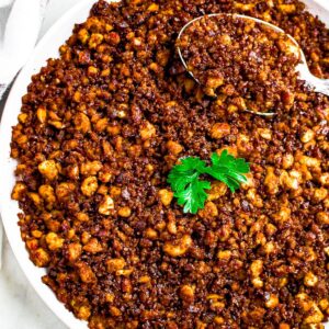 Overhead close up photo of a round white plate of tofu ground beef topped with a parsley leaf