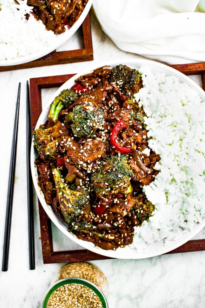 Overhead photo of a plate with vegan beef and broccoli on one side and white rice on the other side.