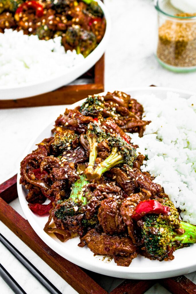 Overhead photo of a plate of vegan beef and broccoli with white rice sprinkled with sesame seeds