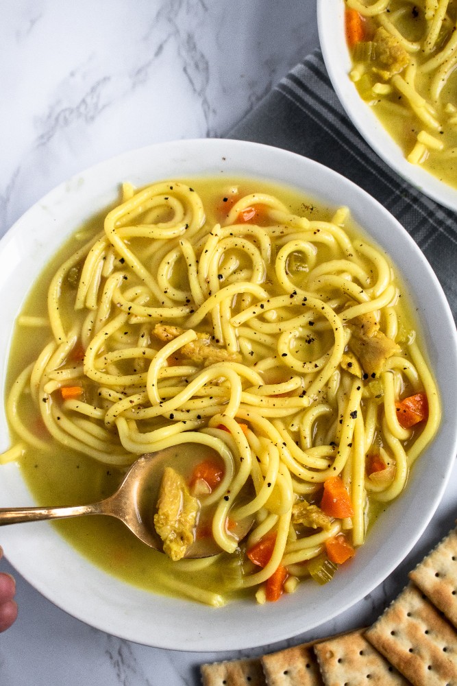 This vegan chicken noodle soup is the stuff of our childhood sick day dreams! Warm + cozy broth bursting with flavor, thick brothy noodles, tender chicken-free chicken. Easy, soothing, gluten-free option. #vegan #soup #plantbased #veganrecipe // plantpowercouple.com
