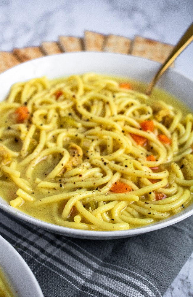 This vegan chicken noodle soup is the stuff of our childhood sick day dreams! Warm + cozy broth bursting with flavor, thick brothy noodles, tender chicken-free chicken. Easy, soothing, gluten-free option. #vegan #soup #plantbased #veganrecipe // plantpowercouple.com