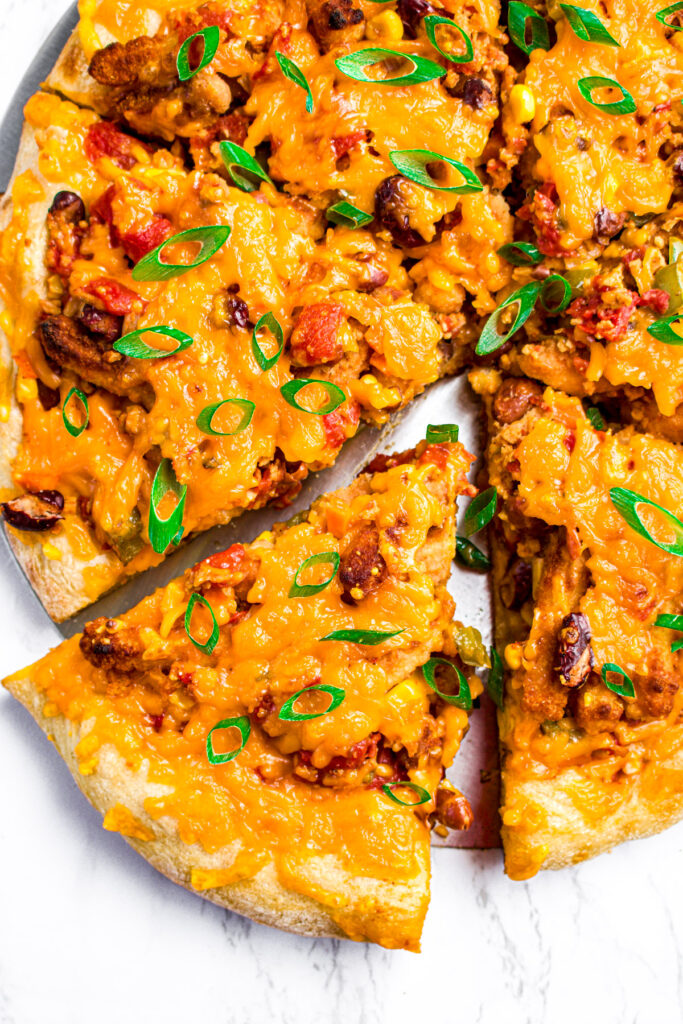 Overhead close up view of a slice of veggie chili pizza with french fries