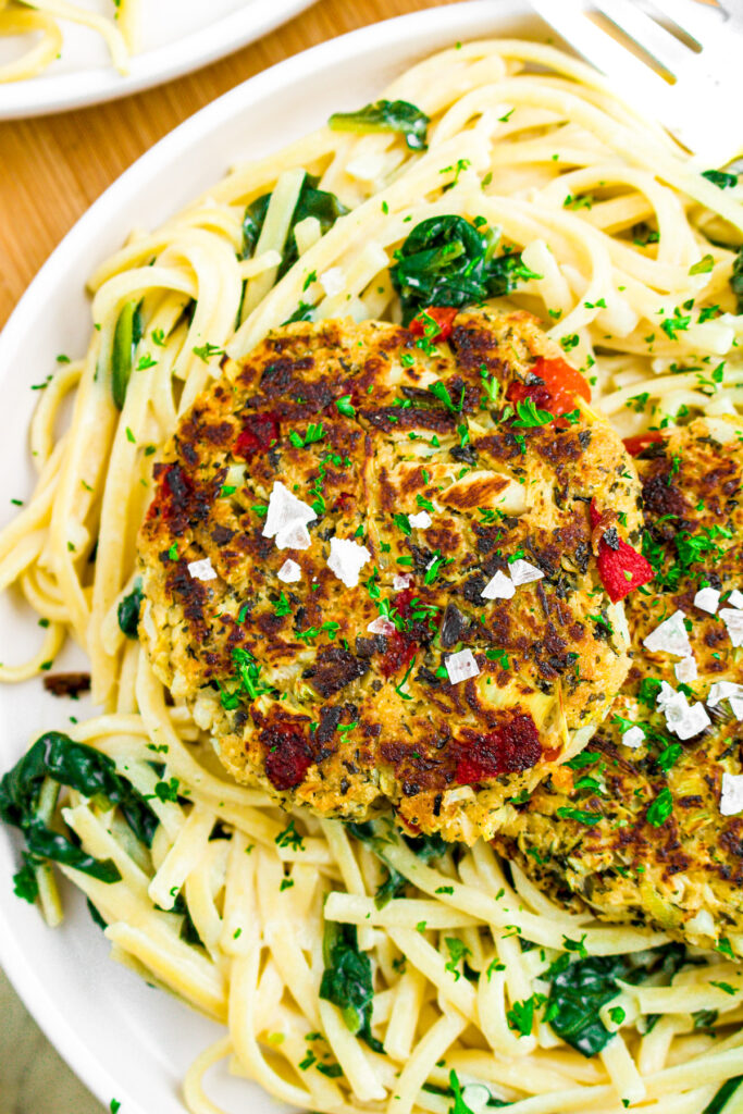 Overhead photo of a plate of creamy fettuccine with crabless cakes on top