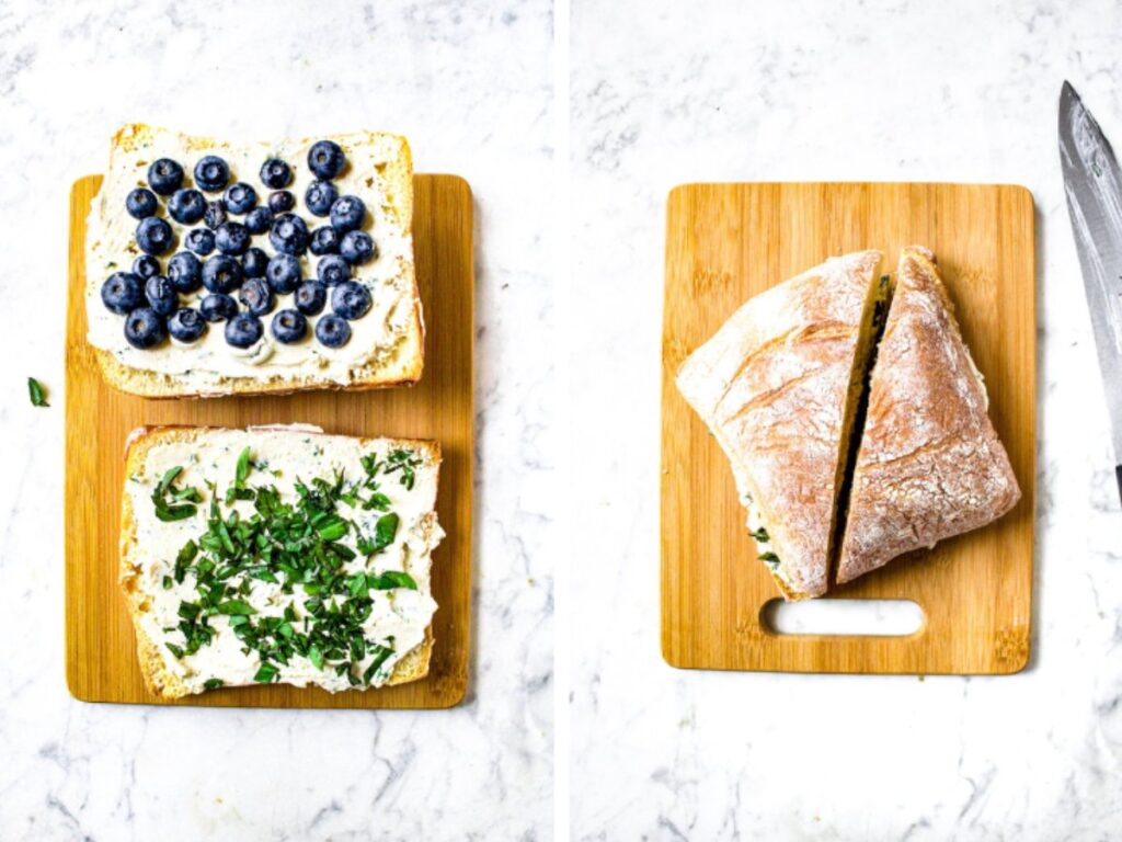 Two side by side photos showing the process of assembling a vegan goat cheese sandwich: The first photo shows the open ciabatta halves with a thick layer of dairy free goat cheese. One half is topped with blueberries. The other half is topped with basil. The second photo is an overhead shot of the sandwich once it's been put together and sliced for serving.