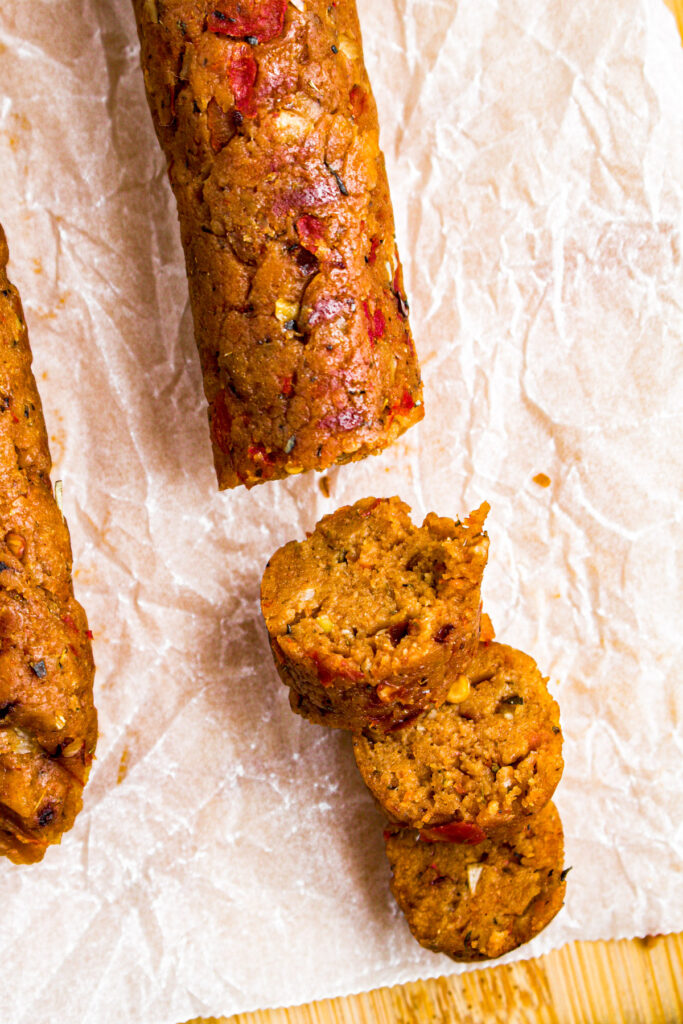 Overhead close up photo of a half-sliced Italian seitan sausage