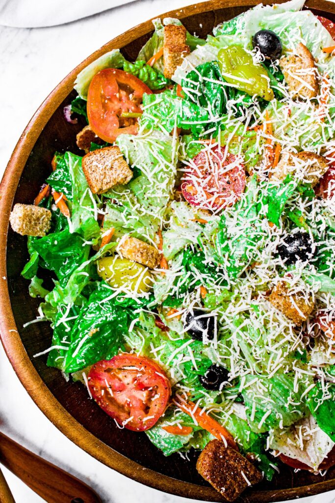 Overhead photo of half a large bamboo bowl filled with copycat Olive Garden salad