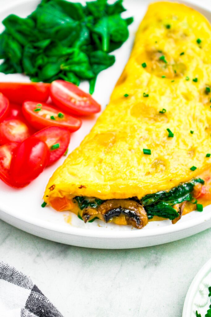 Close up head on photo of a stuffed vegan omelet on a plate.