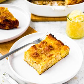 Head on photo of a slice of vegan pineapple stuffing on a round white plate with a jar of crushed pineapple behind it