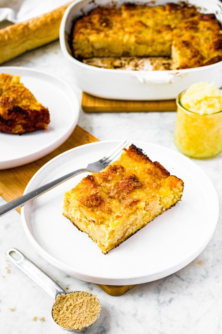 Head on photo of a slice of vegan pineapple stuffing on a round white plate with a jar of crushed pineapple behind it