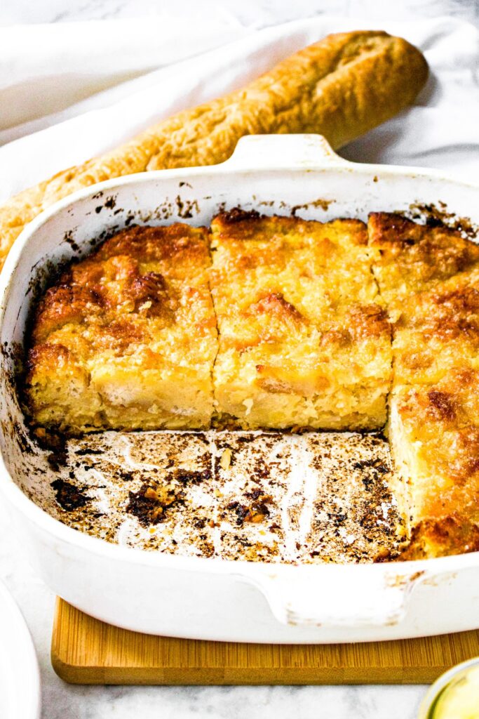 Head on photo of a pan of dairy free pineapple casserole with a 2 slices missing