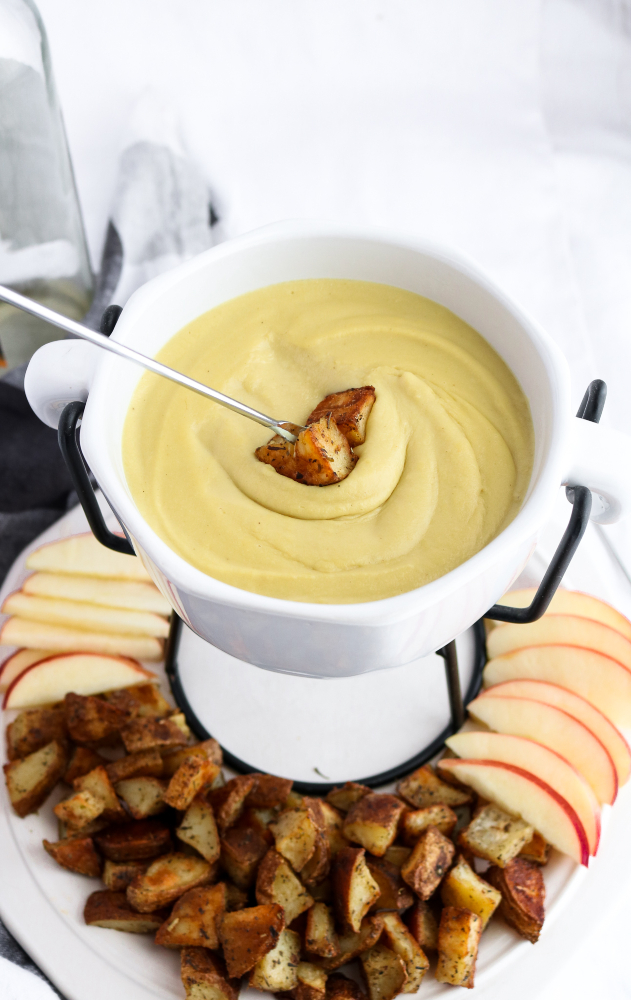 This vegan Irish cheddar + whiskey fondue recipe has a creamy cashew + white bean base with a gooey stretchy texture and the most wonderful tangy zip! Easy to make and great for St. Patrick's Day! #vegan #fondue #dairyfree #whiskey // plantpowercouple.com